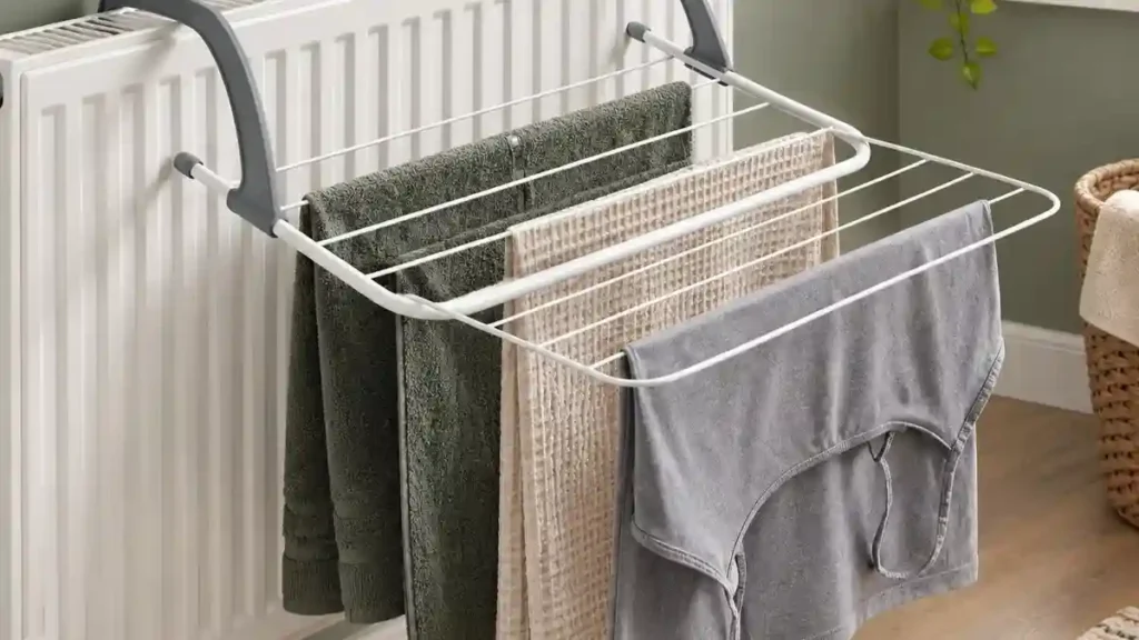 Clip-on radiator drying rack holding towels and a t-shirt, a safer alternative to draping wet clothes directly on a radiator