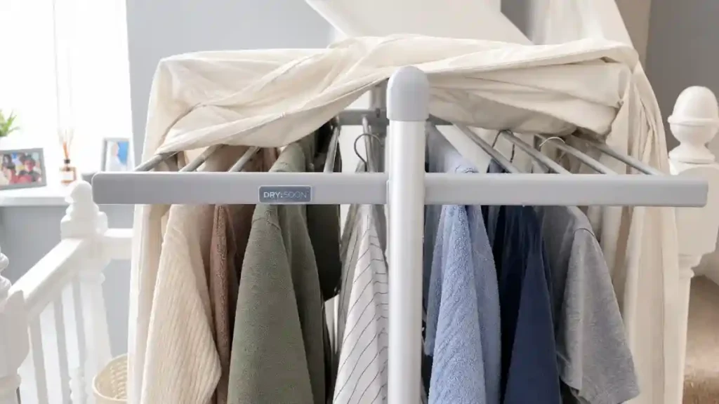 Bedsheet draped over a clothes airer to trap warm air and help dry clothes faster, known as the bedsheet tent trick